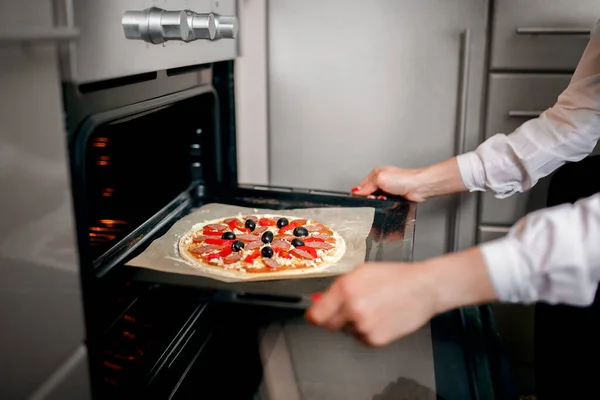 Rå pizza med ingredienser på bakplåt — Stockfoto