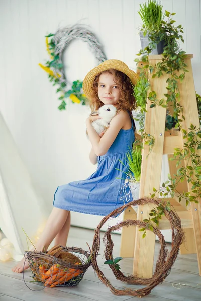 Mutlu küçük kız bir tavşanla oynuyor, gerçek tavşancığına sarılıyor ve bir hayvanla ilgilenmeyi öğreniyor. — Stok fotoğraf