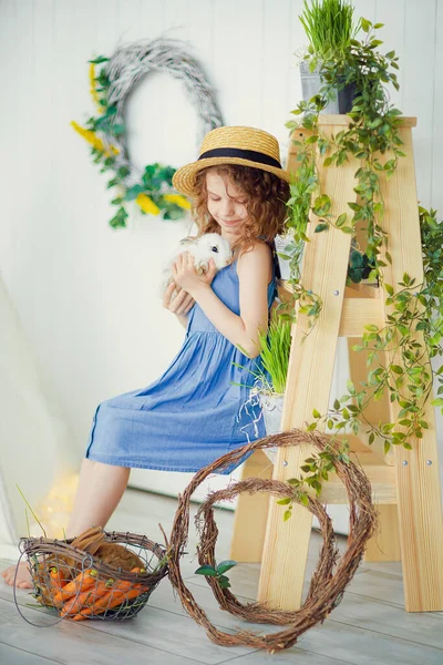 Feliz rindo menina brincando com um bebê coelho, abraçando seu animal de estimação coelho real e aprender a cuidar de um animal — Fotografia de Stock