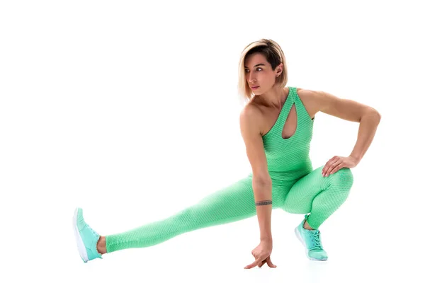 Helkroppsporträtt av ung sportig kvinna stretching innan motion isolerad på vit bakgrund — Stockfoto
