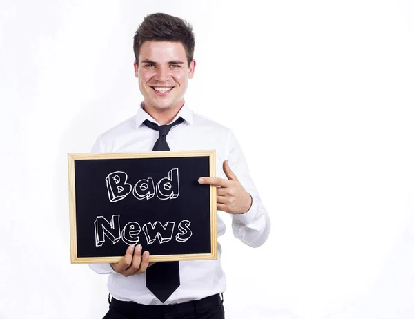 Kötü haber - tex ile kara tahta tutan genç gülümseyen iş adamı — Stok fotoğraf