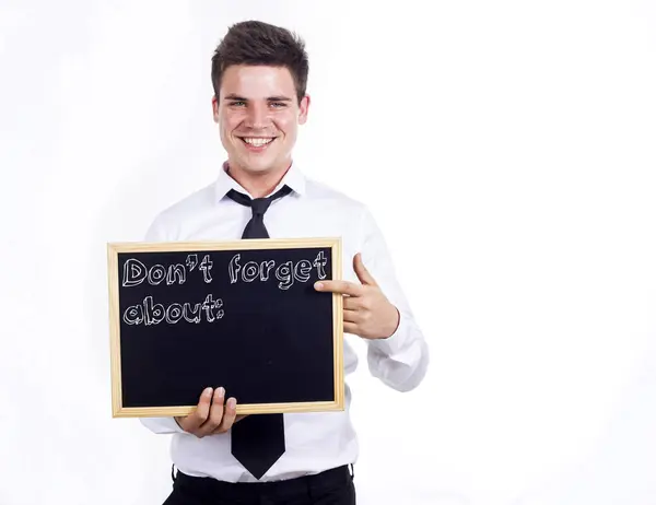 No te olvides de - Joven hombre de negocios sonriente sosteniendo chalkbo — Foto de Stock