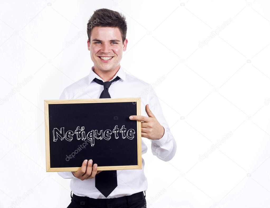 Netiquette - Young smiling businessman holding chalkboard with t