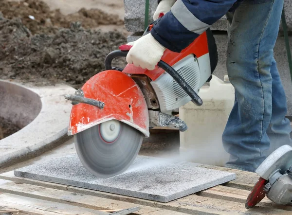 Construction worker operated Circular saw with a diamond blade for cutting asphalt and concrete
