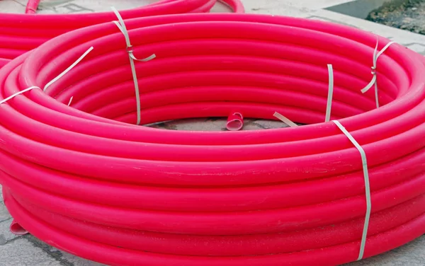 Many long red industrial plastic pipe for building