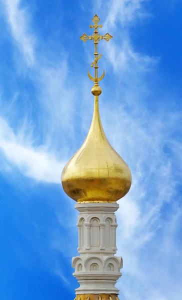 The dome of the Church with a cross against the blue sky