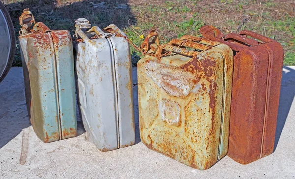 a rusty old metal gasoline cans with peeling paint