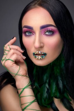 Akşam makyaj, rhinestones ve tüy boyun yeşil dudak ile güzel kız. Güzellik yüz. Fotoğraf stüdyosunda vurdu. Yakın çekim