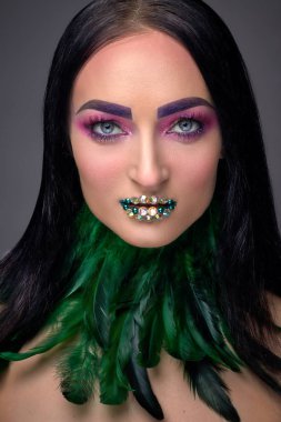 Akşam makyaj, rhinestones ve tüy boyun yeşil dudak ile güzel kız. Güzellik yüz. Fotoğraf stüdyosunda vurdu. Yakın çekim