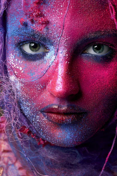 Female face art with creative make up. Closeup cropped studio portrait of young fashion model isolated with bright colorful mix of paint — Stock Photo, Image