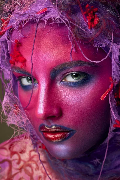 Female face art with creative make up. Closeup cropped studio portrait of young fashion model isolated with bright colorful mix of paint — Stock Photo, Image