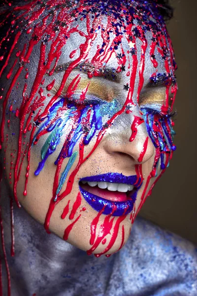 Menina bonita com fluindo para baixo vermelho azul pintura facial, brilho rosto, estúdio de perto retrato — Fotografia de Stock