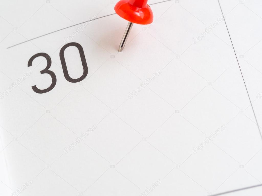 Red pin on 30 calendar paper