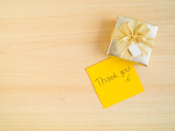 Thank you words on sticky note with gift box