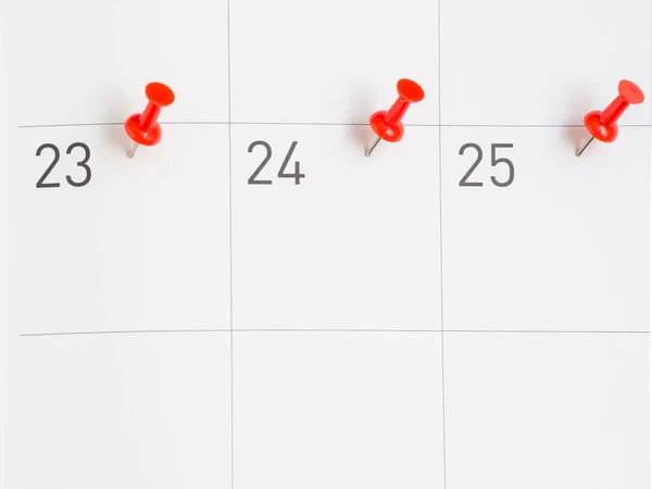 Červené kolíky připnul na papíře kalendář — Stock fotografie