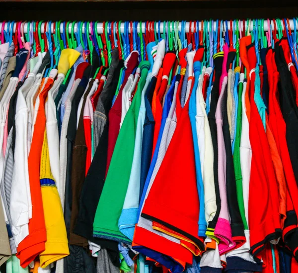 Many color shirts hanging in wardrobe.