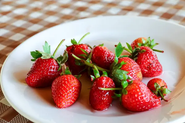 Çilek vardır üzerinde beyaz bir tabak.