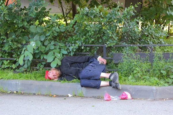 Sleeping on the lawn drunk, Prospekt Bolshevikov, Saint-Petersburg, Russia August 2017 — Stock Photo, Image