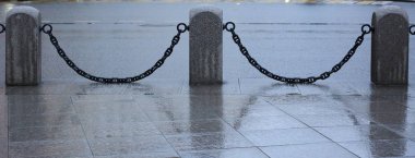 Metal zincirli granit sütunların ortası.