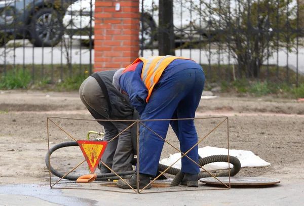 Dos Trabajadores Doblados Sobre Una Alcantarilla Calle —  Fotos de Stock