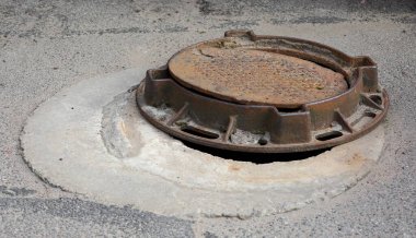 Asfaltta kapağı olan paslı metal bir rögar kaldırılmıştı.