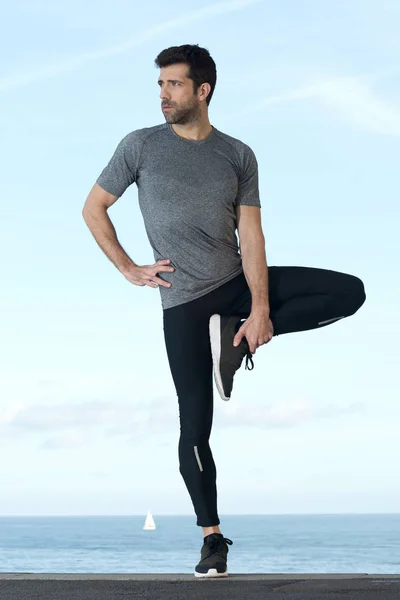 Sportsman stretches leg — Stock Photo, Image