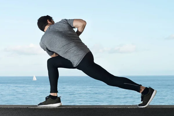 Sportsman doing warm-ups before running — Stock Photo, Image