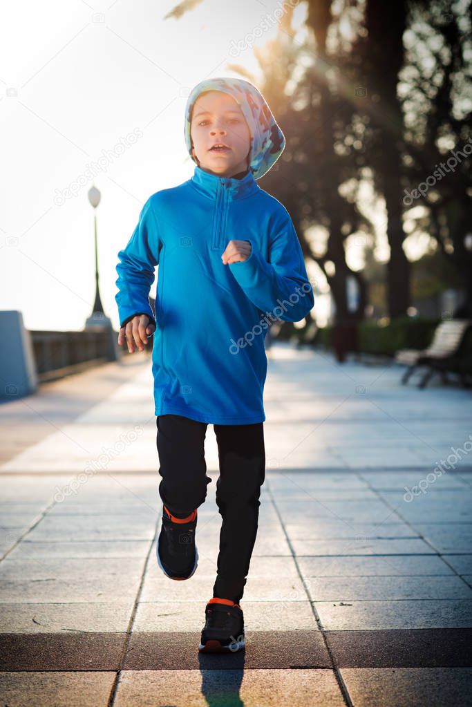 little boy running -with lens flare