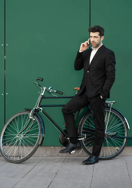 Homem vestido de terno com bicicleta clássica fala ao telefone — Fotografia de Stock