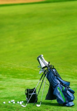 Golf sahasında bir çanta dolusu golf sopası dikey fotokopi alanı
