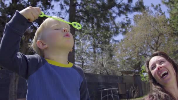 Aranyos gyermek folyamatosan próbál csapást buborék, amíg nem sikerül — Stock videók