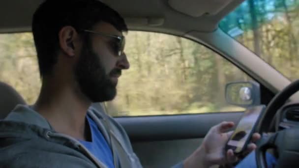 Hombre usando el teléfono mientras conduce — Vídeos de Stock