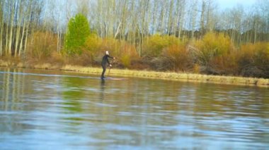 Wetsuit erkekte Nehri üzerinde kayar