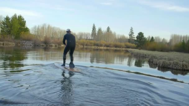 Hombre en traje de neopreno lanza desde la orilla — Vídeo de stock