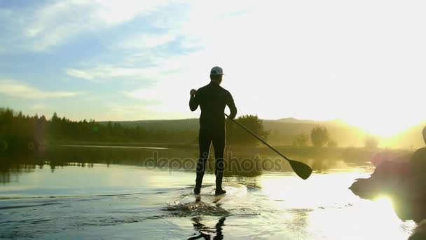 Man in wetsuit peddel glijdt op rivier — Stockvideo