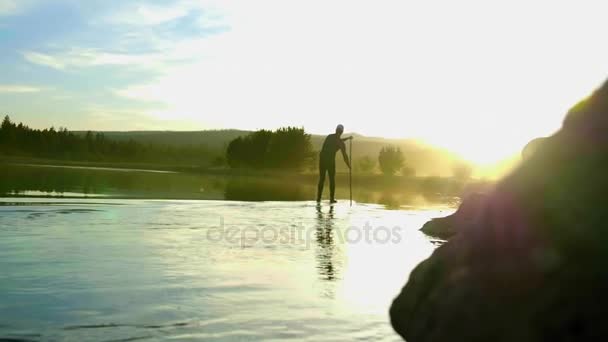 Mann im Neoprenanzug paddelt auf Fluss — Stockvideo