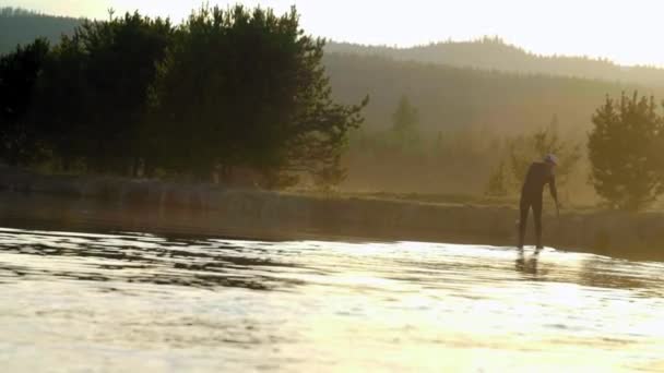 Mannen i våtdräkt paddleboarding — Stockvideo