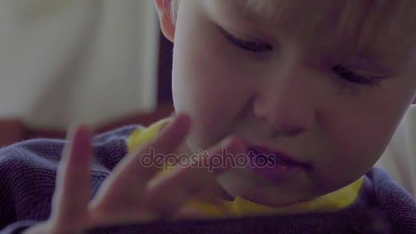 Close-up shot van schattige jongen met behulp van een mobiele telefoon — Stockvideo