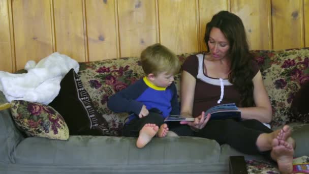 Мать читает книгу сыну — стоковое видео