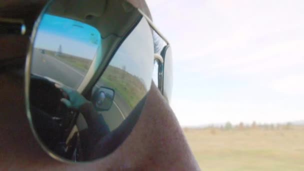 Man in sunglasses with reflection of road — Stock Video