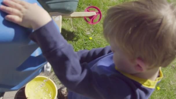 Jongen opvult met een gele emmer — Stockvideo