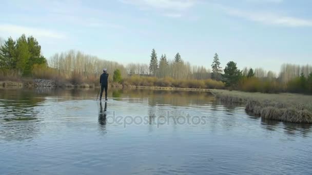 Mann im Neoprenanzug gleitet auf Fluss — Stockvideo