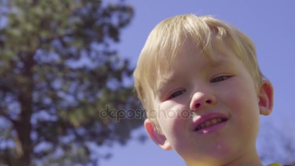 Garçon essayant de souffler des bulles — Video