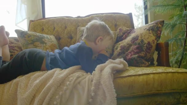 Niño pequeño acostado con teléfono inteligente — Vídeos de Stock