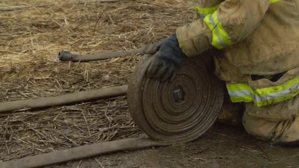 Пожарные сворачивают свои шланги — стоковое видео