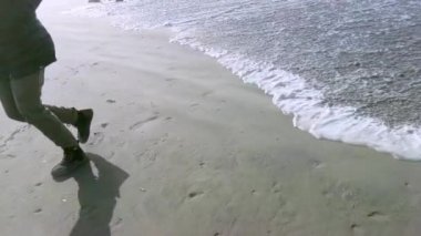 Kıyı şeridinde güneşli bir günde seçici odaklı bir kadın.