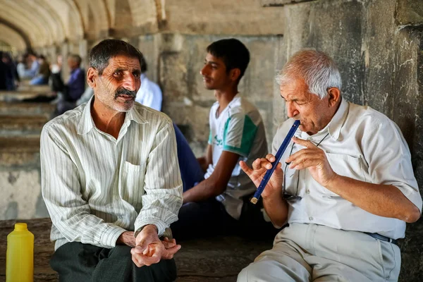 iran, Isfahan Province, Esfahan, Khajoo Bridge, Khaju  - September 2016: elderly men play the flute near in the city center