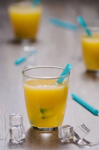 Jus d'orange fraîchement pressé en verre avec paille bleue et glace c — Photo