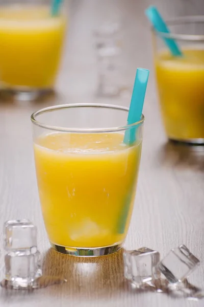 Φρεσκοστυμμένο χυμό πορτοκαλιού, σε ποτήρι με μπλε άχυρο και πάγου c — Φωτογραφία Αρχείου