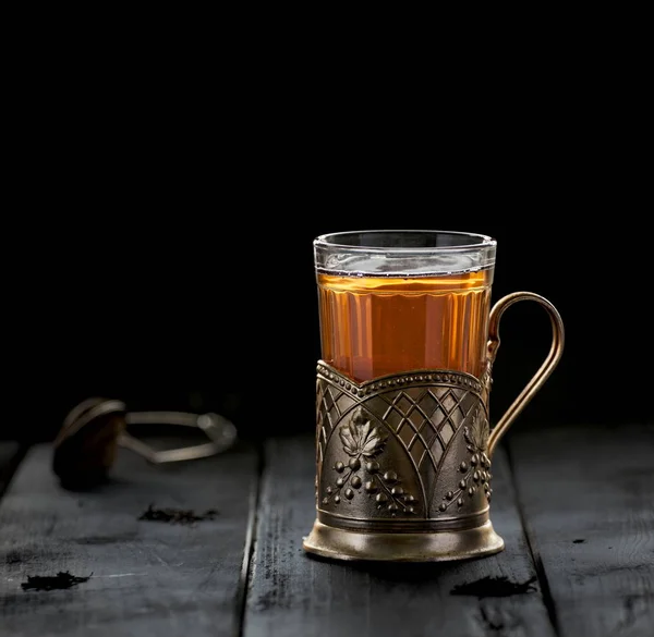 Traditional Russian tea served in glass with vintage brass glass holder podstakannik